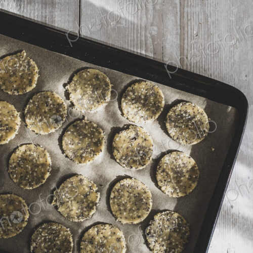High angle close up of seeded cracker dough on a baking tray. High angle close up of seeded cracker dough on a baking tray.