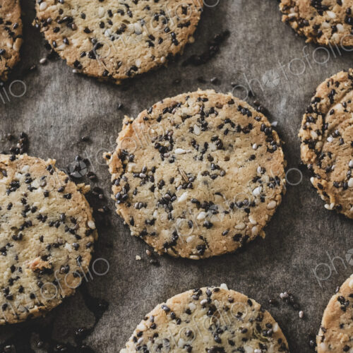 High angle close up of seeded cracker dough on a baking tray.