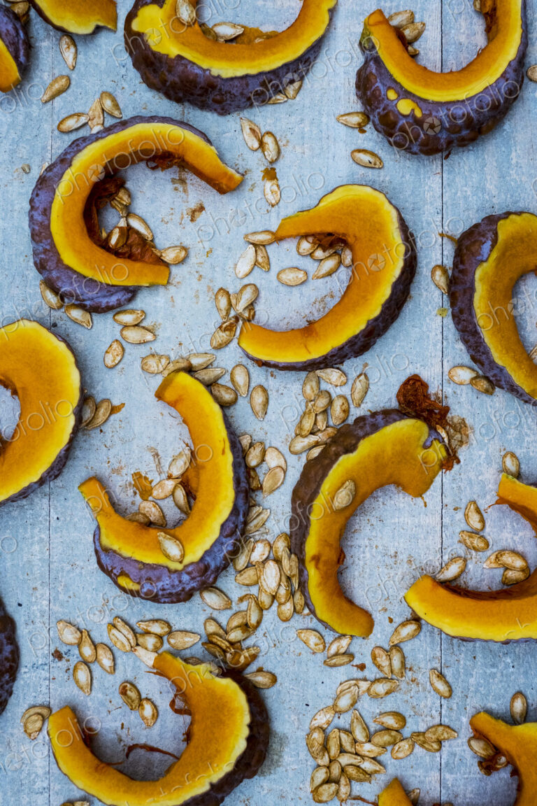 High angle close up of slices of pumpkin on blue background.