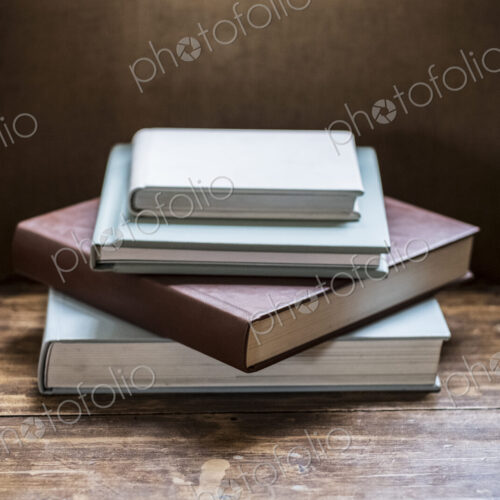 High angle close up of stack of books on wooden table.