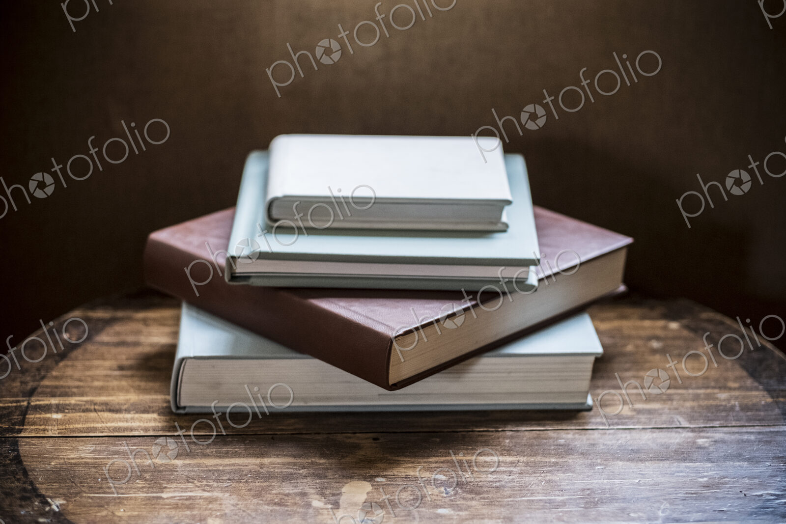 High angle close up of stack of books on wooden table.