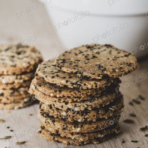 High angle close up of stack of freshly baked seeded crackers. High angle close up of stack of freshly baked seeded crackers.