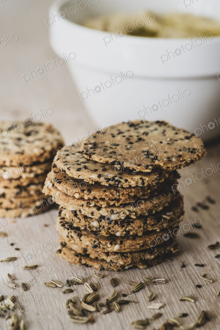 High angle close up of stack of freshly baked seeded crackers.