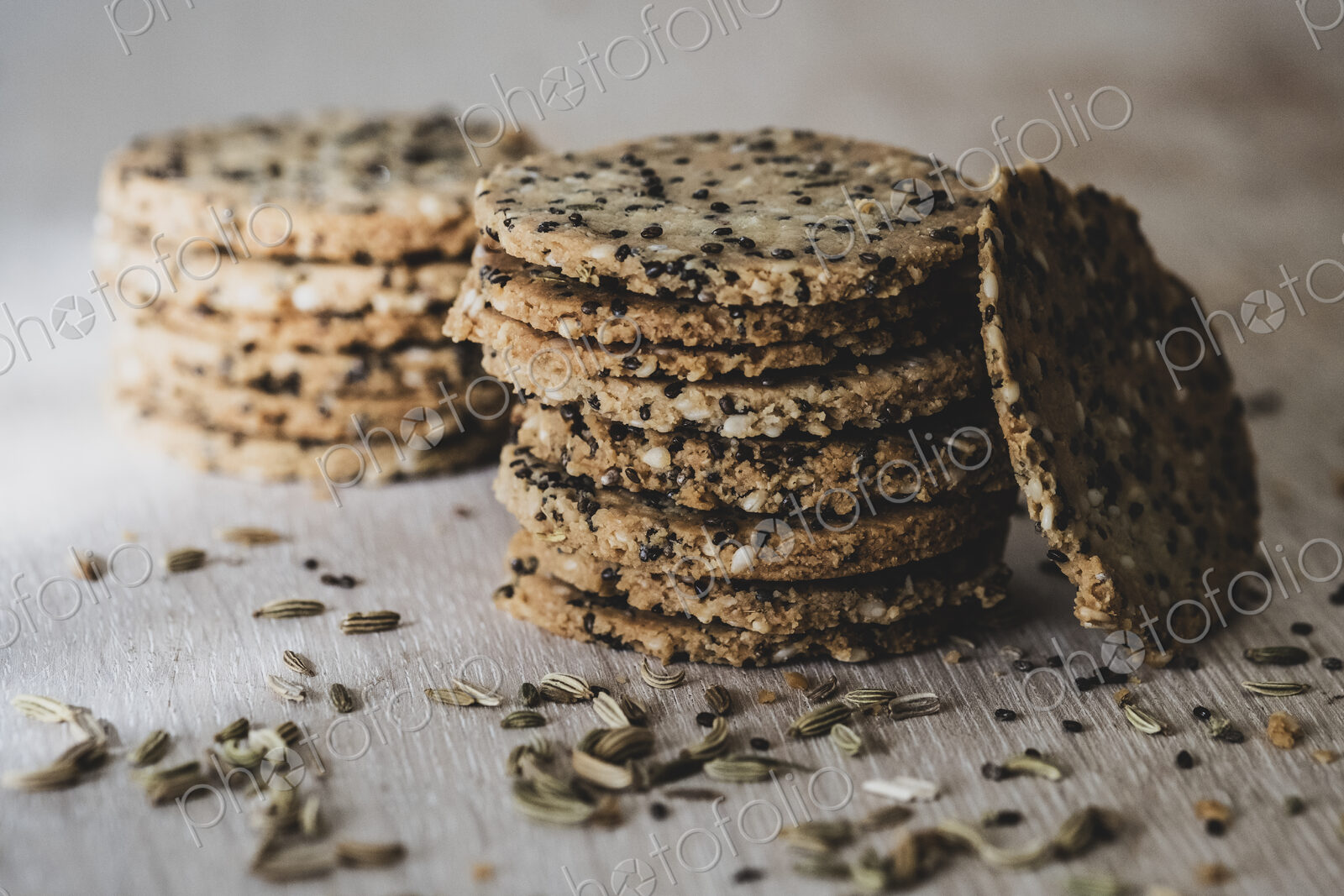 High angle close up of stack of freshly baked seeded crackers.