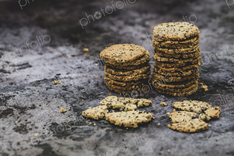 High angle close up of stack of freshly baked seeded crackers.