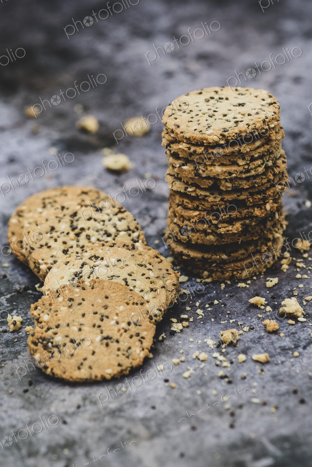 High angle close up of stack of freshly baked seeded crackers.
