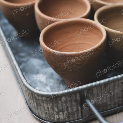 High angle close up of terracotta plant pots on metal tray.