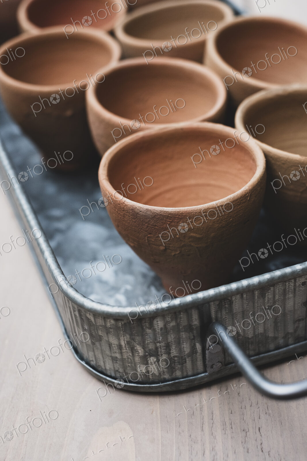 High angle close up of terracotta plant pots on metal tray.