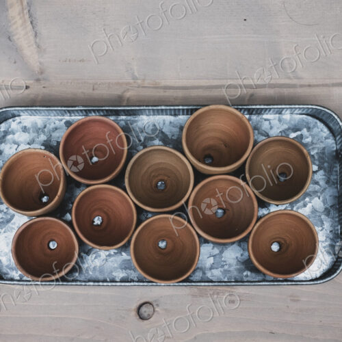 High angle close up of terracotta plant pots on metal tray. High angle close up of terracotta plant pots on metal tray.