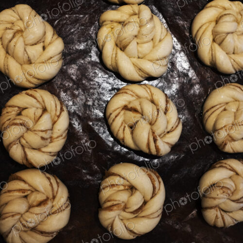 High angle close up of tray with cinnamon buns in an artisan bakery.