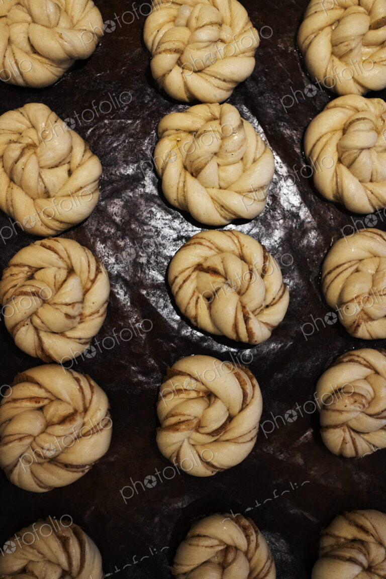 High angle close up of tray with cinnamon buns in an artisan bakery.