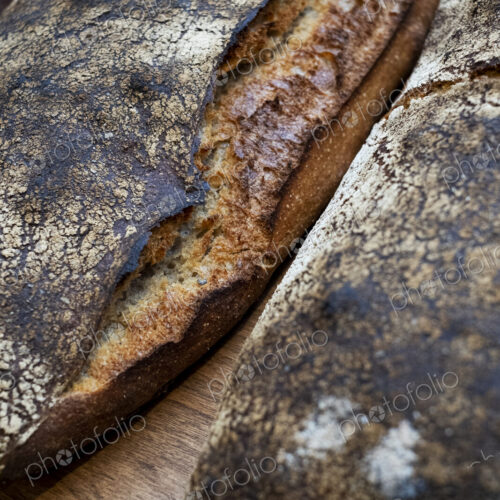 High angle close up of two freshly baked loaves of bread in an artisan bakery.