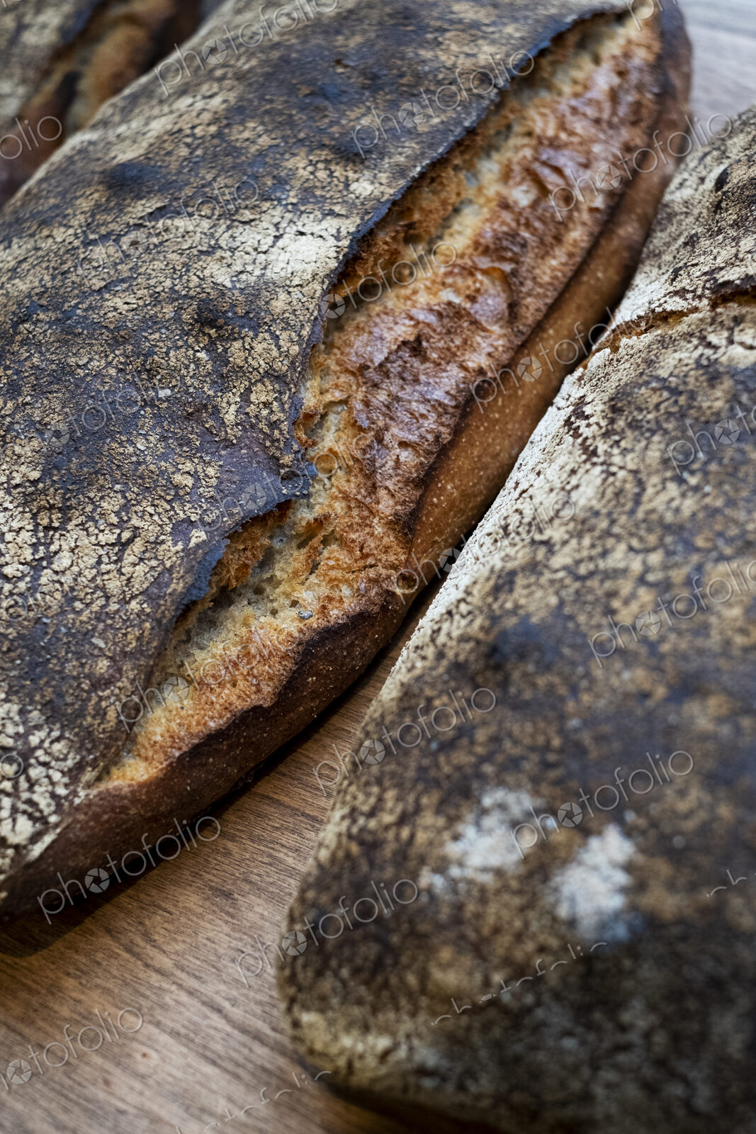 High angle close up of two freshly baked loaves of bread in an artisan bakery.