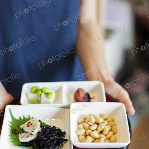 High angle close up of waitress holding a selection of vegetarian Japanese foods in a… High angle close up of waitress holding a selection of vegetarian Japanese foods in a…