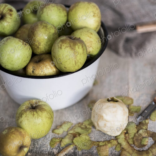 High angle close up of white bowl with green apples. High angle close up of white bowl with green apples.