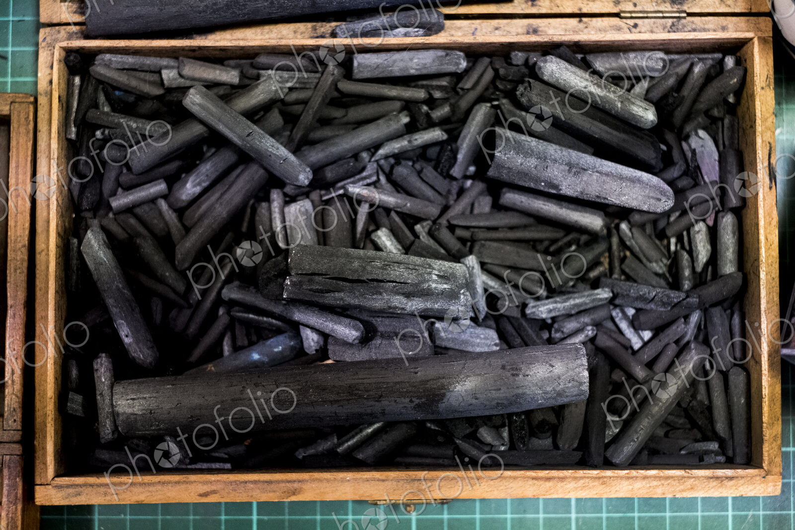 High angle close up of wooden box with a selection of artist’s charcoal sticks in…