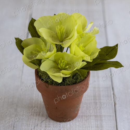 High angle close up of yellow paper flowers in a terracotta flowerpot. High angle close up of yellow paper flowers in a terracotta flowerpot.