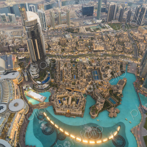 High angle view from tall skyscraper into urban area with pools and fountains. High angle view from tall skyscraper into urban area with pools and fountains.