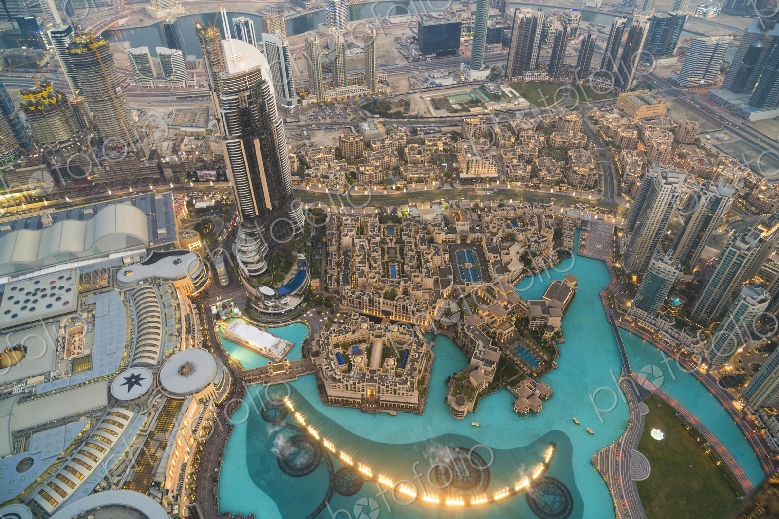High angle view from tall skyscraper into urban area with pools and fountains.