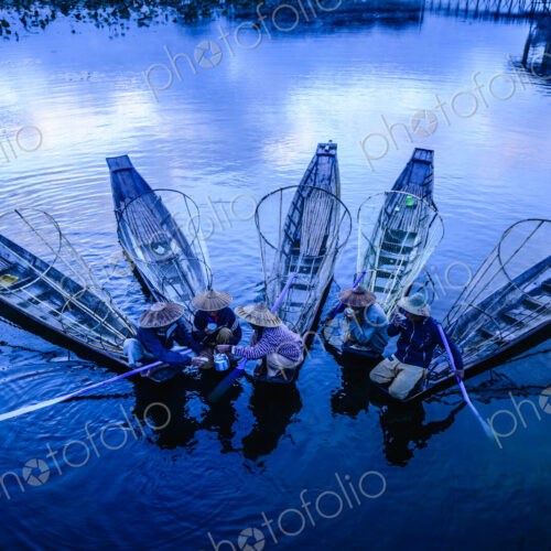 High angle view of Asian fishermen fishing in canoes on river High angle view of Asian fishermen fishing in canoes on river