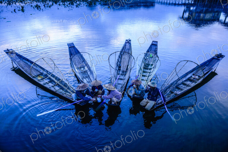 High angle view of Asian fishermen fishing in canoes on river