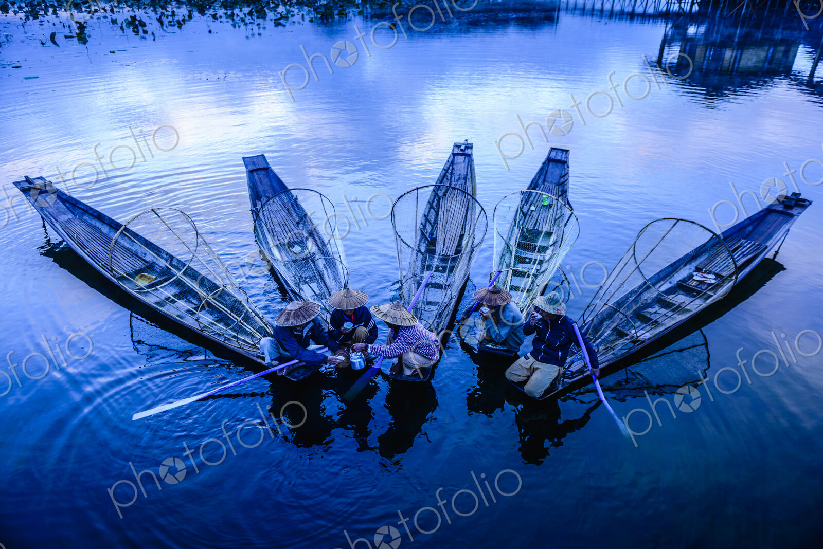 High angle view of Asian fishermen fishing in canoes on river