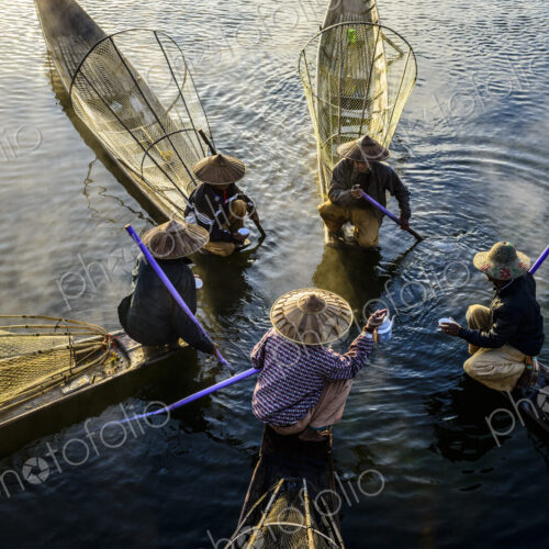 High angle view of Asian fishermen fishing in canoes on river High angle view of Asian fishermen fishing in canoes on river