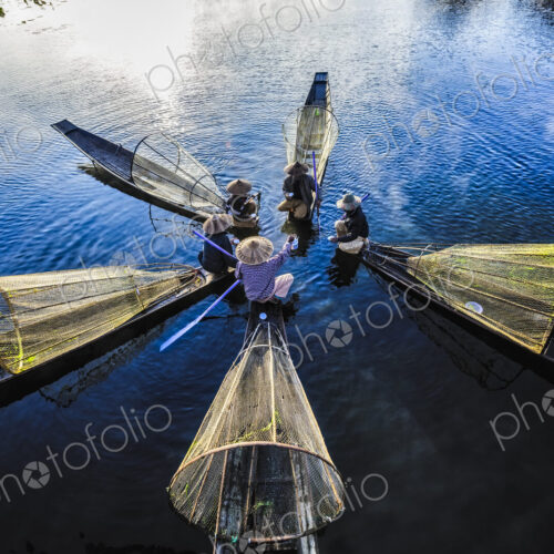 High angle view of Asian fishermen fishing in canoes on river High angle view of Asian fishermen fishing in canoes on river