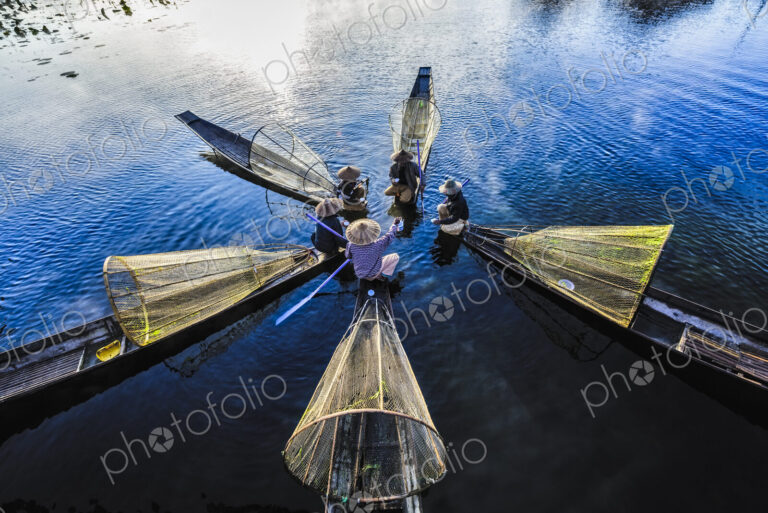 High angle view of Asian fishermen fishing in canoes on river