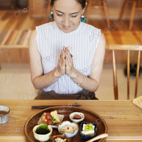 High angle view of Japanese woman sitting in front of a selection of vegetarian food… High angle view of Japanese woman sitting in front of a selection of vegetarian food…