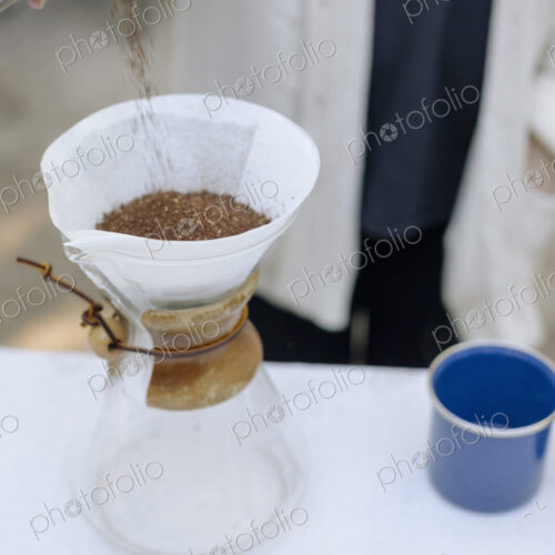 High angle view of a glass coffee maker, a conical jar with filter paper and coffee…