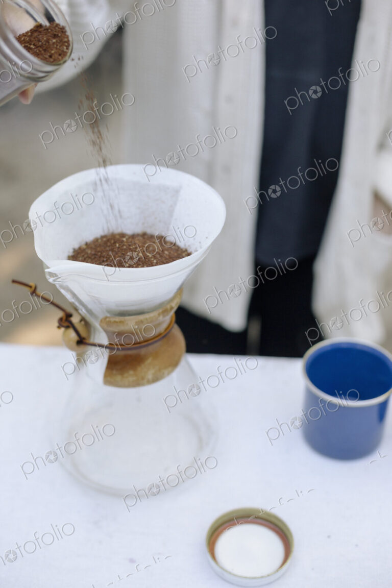 High angle view of a glass coffee maker, a conical jar with filter paper and coffee…
