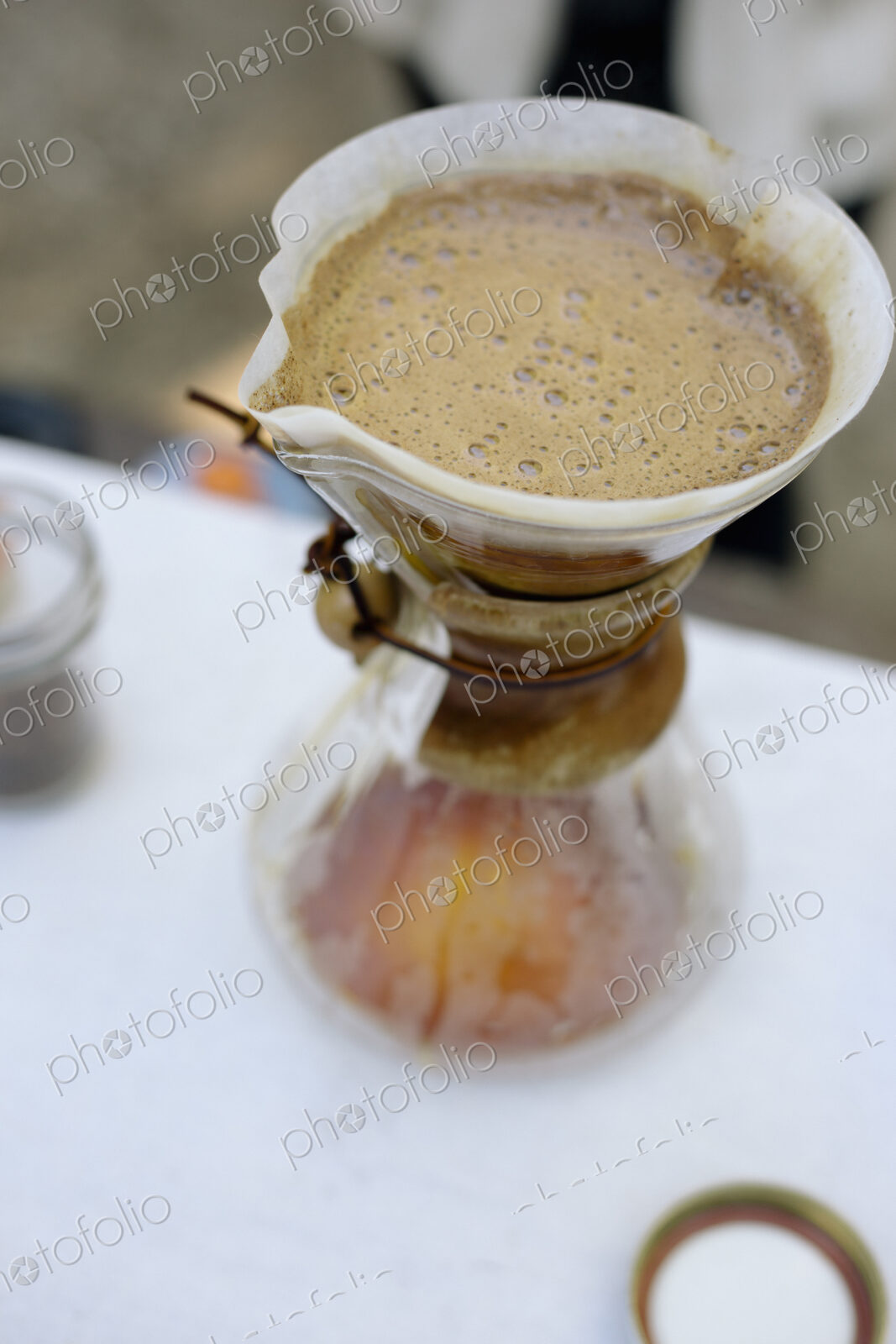 High angle view of a glass coffee maker and filter paper with coffee and water…
