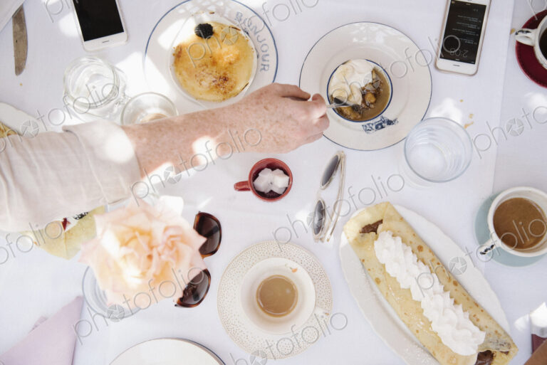 High angle view of a table with food and drink, deserts, pancake with cream, and cups…