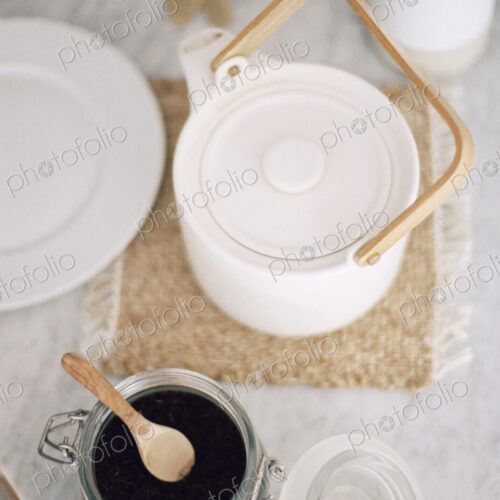 High angle view of a tea pot and a glass jar with tea leaves. High angle view of a tea pot and a glass jar with tea leaves.