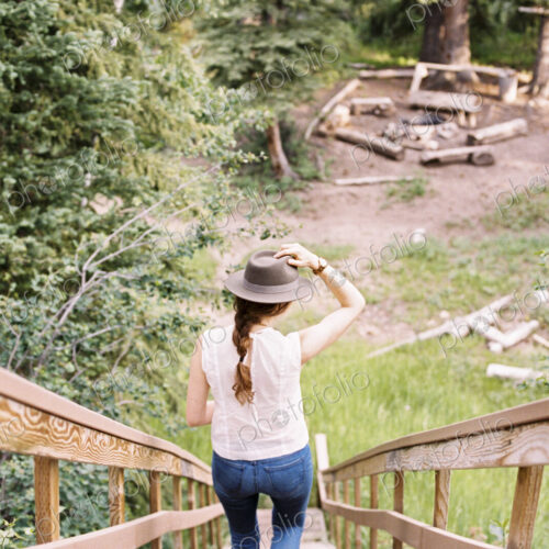 High angle view of a woman walking down a steep wooden staircase.
