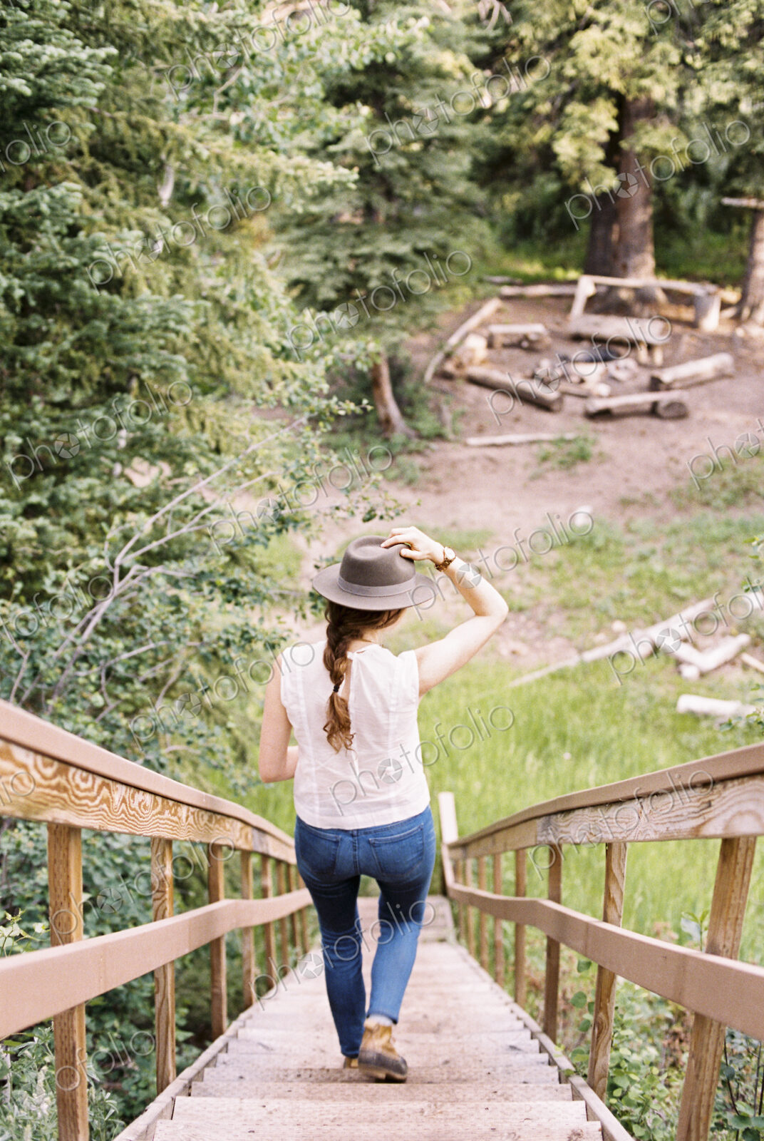 High angle view of a woman walking down a steep wooden staircase.