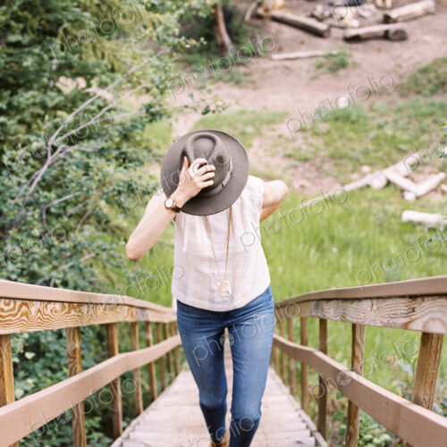 High angle view of a woman walking up a steep wooden staircase.