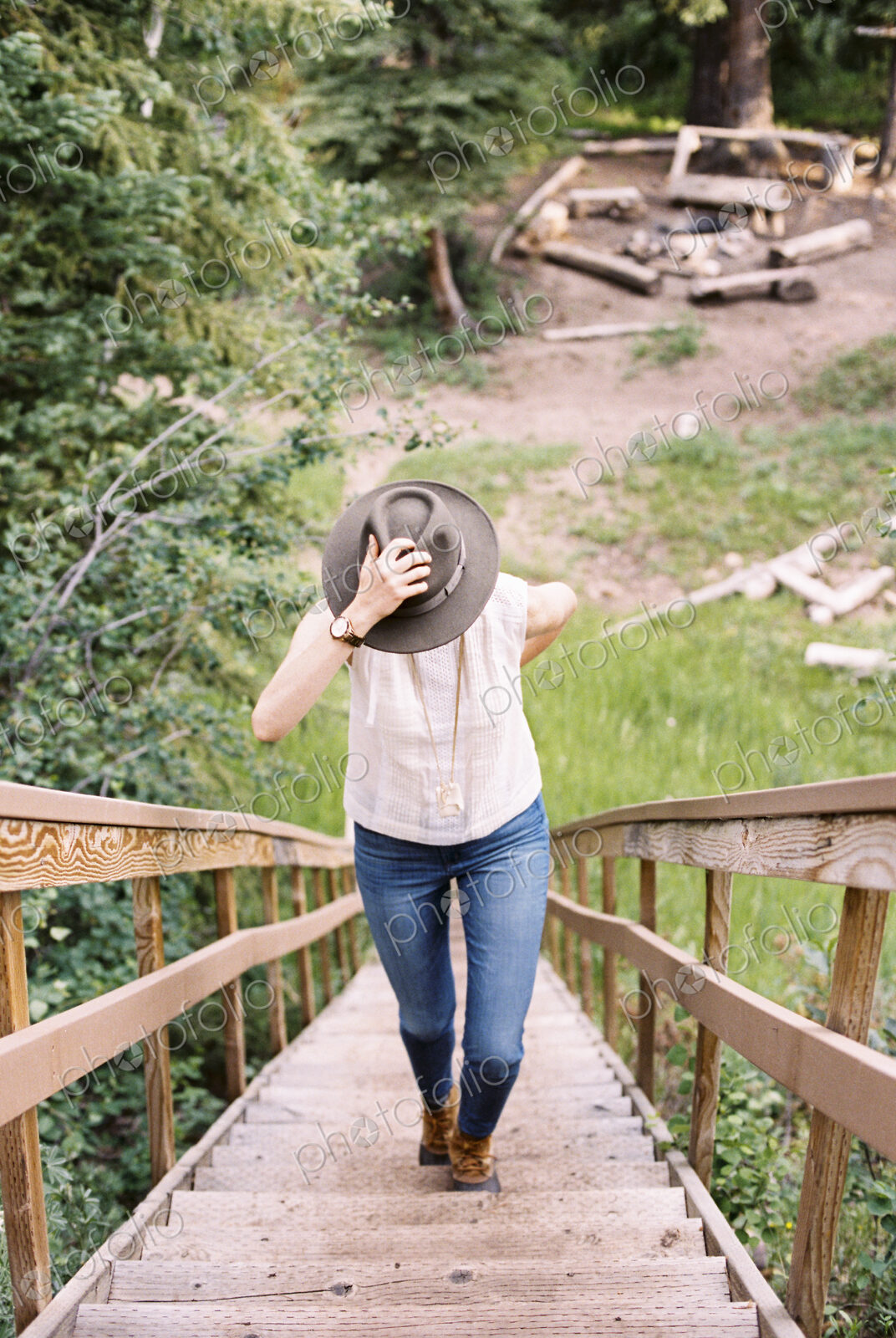 High angle view of a woman walking up a steep wooden staircase.