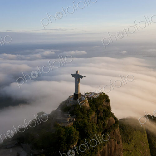 High angle view of colossal Christ Redeemer statue surrounded by clouds, Corcovado,… High angle view of colossal Christ Redeemer statue surrounded by clouds, Corcovado,…