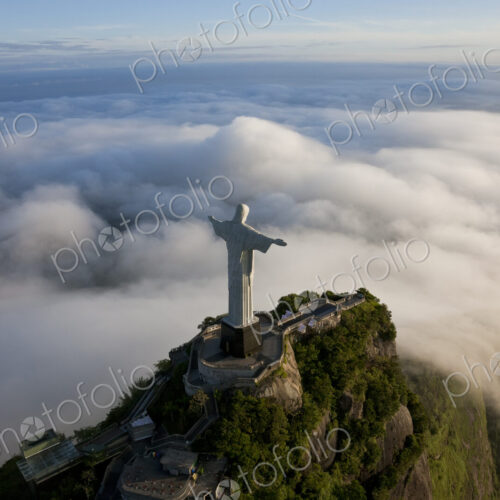 High angle view of colossal Christ Redeemer statue surrounded by clouds, Corcovado,… High angle view of colossal Christ Redeemer statue surrounded by clouds, Corcovado,…