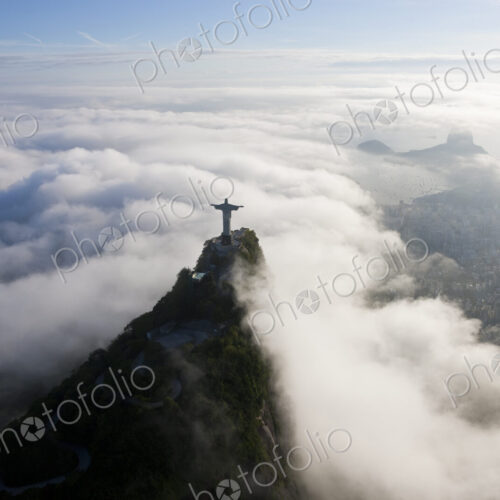 High angle view of colossal Christ Redeemer statue surrounded by clouds, Corcovado,… High angle view of colossal Christ Redeemer statue surrounded by clouds, Corcovado,…