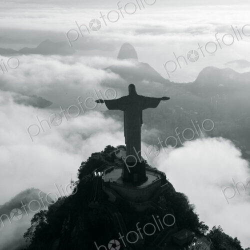 High angle view of colossal Christ Redeemer statue surrounded by clouds, Corcovado,… High angle view of colossal Christ Redeemer statue surrounded by clouds, Corcovado,…