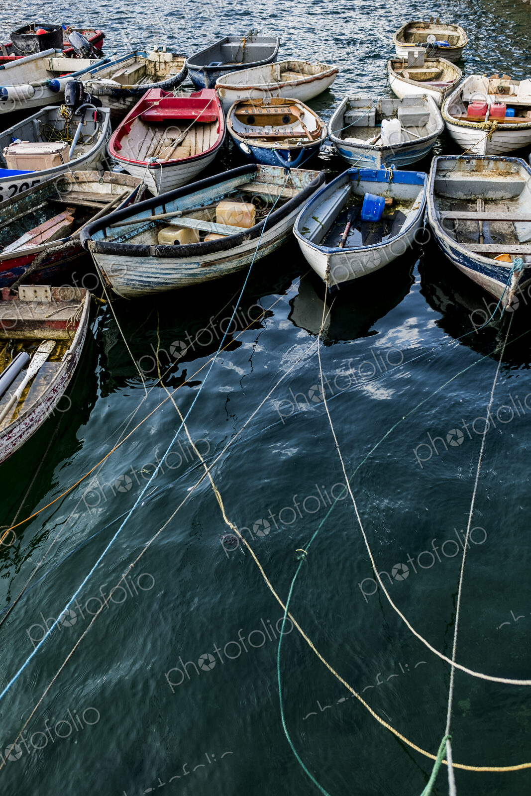 High angle view of colourful wooden fishing boats moored side by side in an harbour.