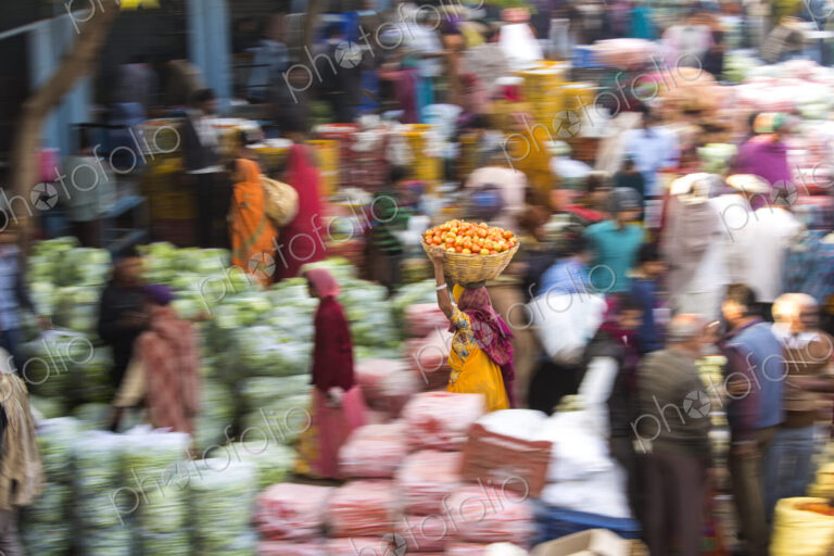 High angle view of fruit and vegetable market, woman carrying a load on her head,…