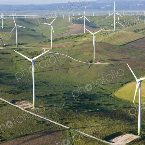 High angle view of rolling landscape with fields and wind turbines.