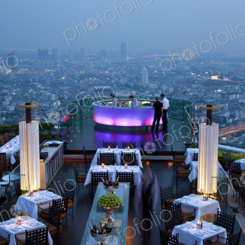 High angle view of rooftop restaurant on a skyscraper, illuminated cityscape in the… High angle view of rooftop restaurant on a skyscraper, illuminated cityscape in the…
