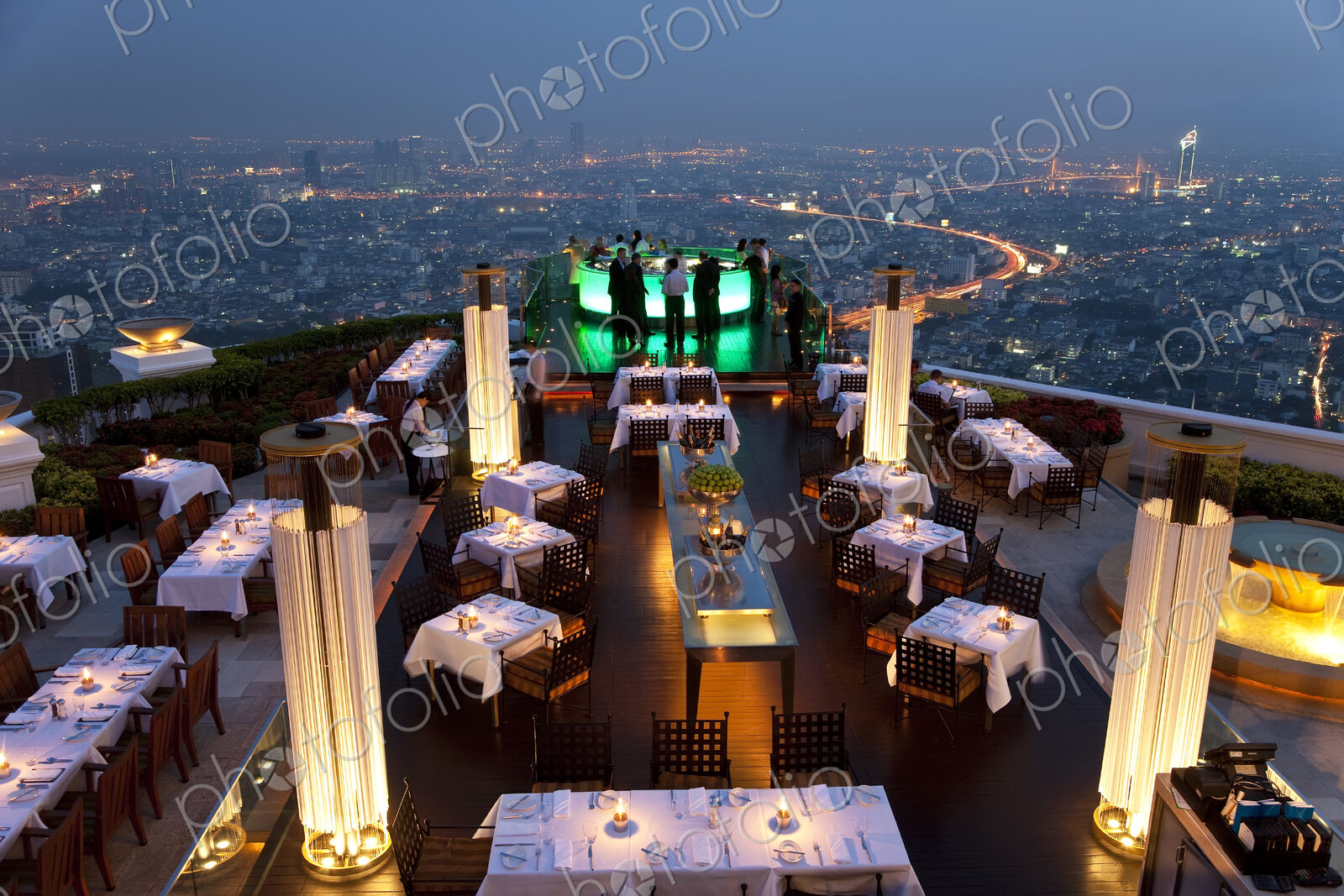 High angle view of rooftop restaurant on a skyscraper, illuminated cityscape in the…