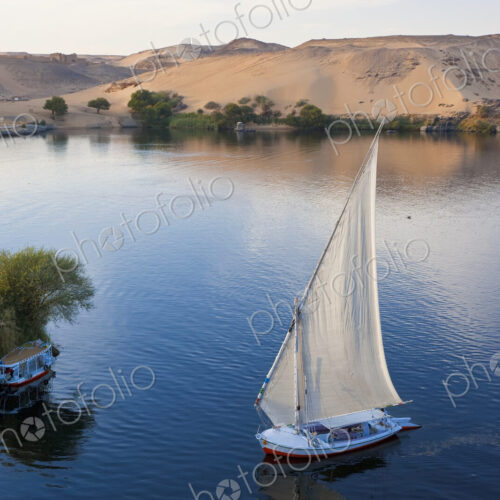High angle view of sailboat on a lake, sand hills in the distance. High angle view of sailboat on a lake, sand hills in the distance.