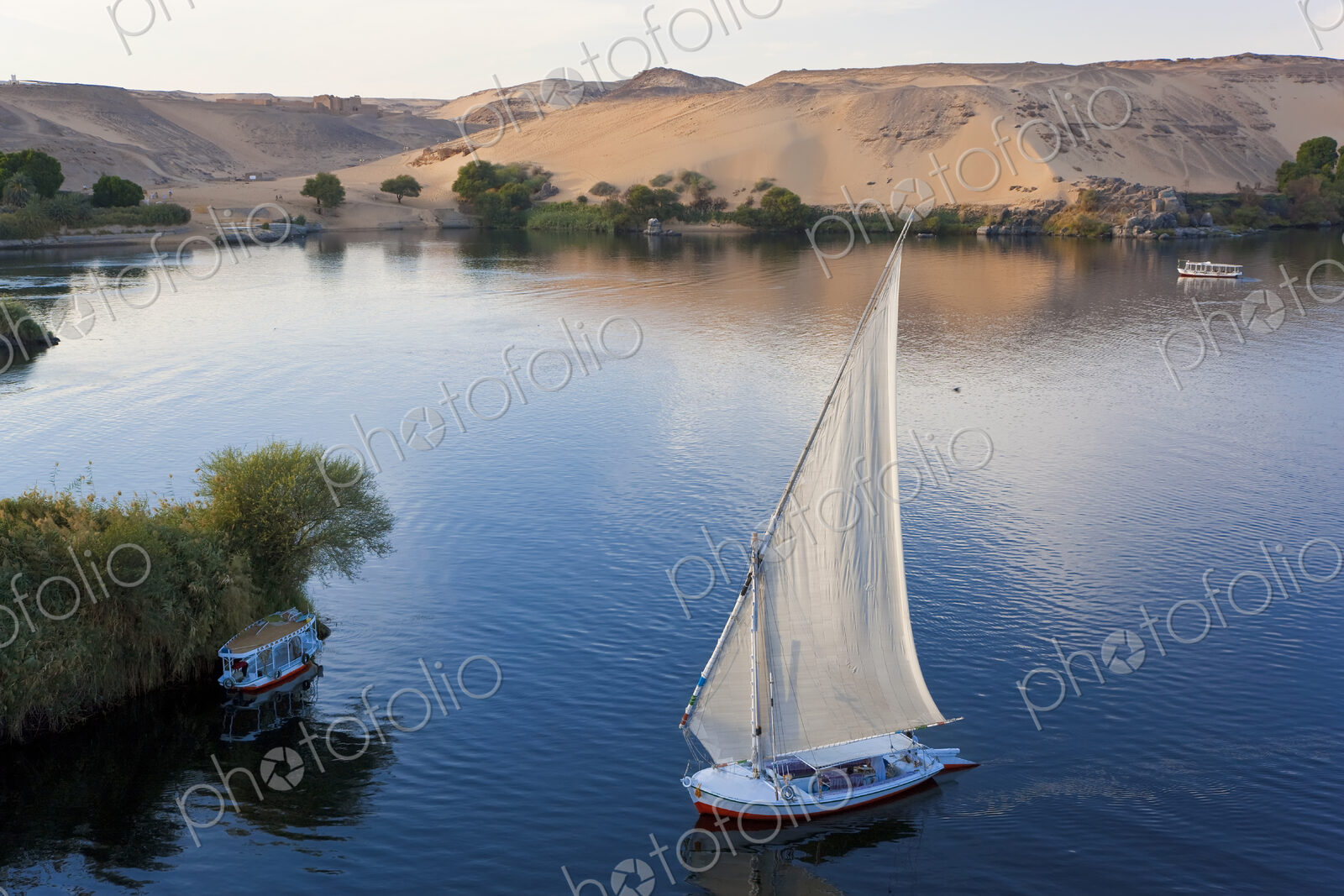 High angle view of sailboat on a lake, sand hills in the distance.